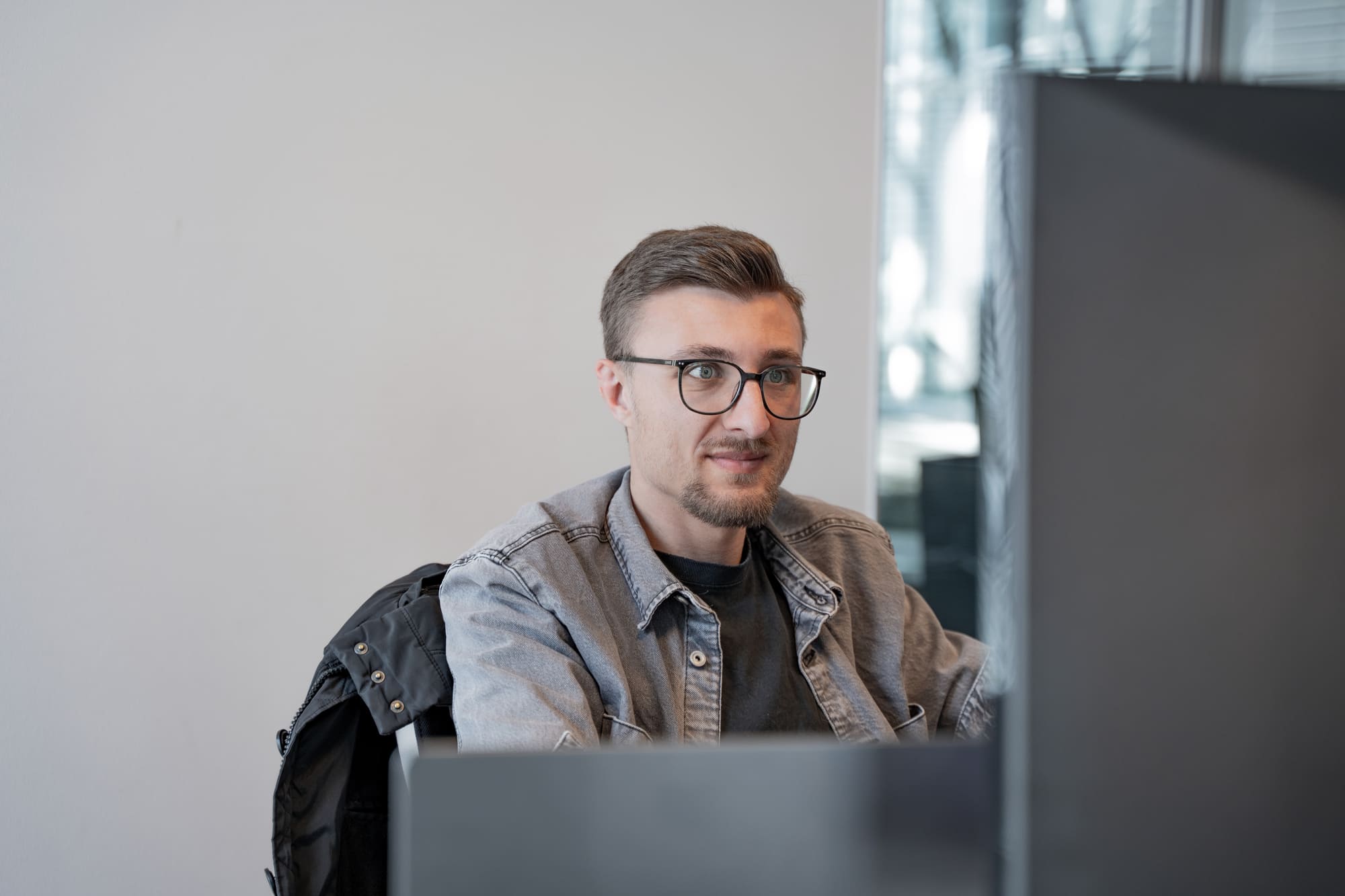 Pascal aus dem Team von digitalbynature bei der Arbeit am Rechner im hellen Büro
