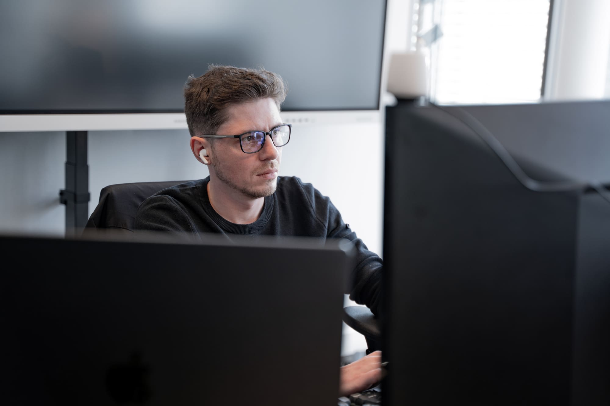 Sergej aus dem Team von digitalbynature konzentriert vor dem Bildschirm im Büro