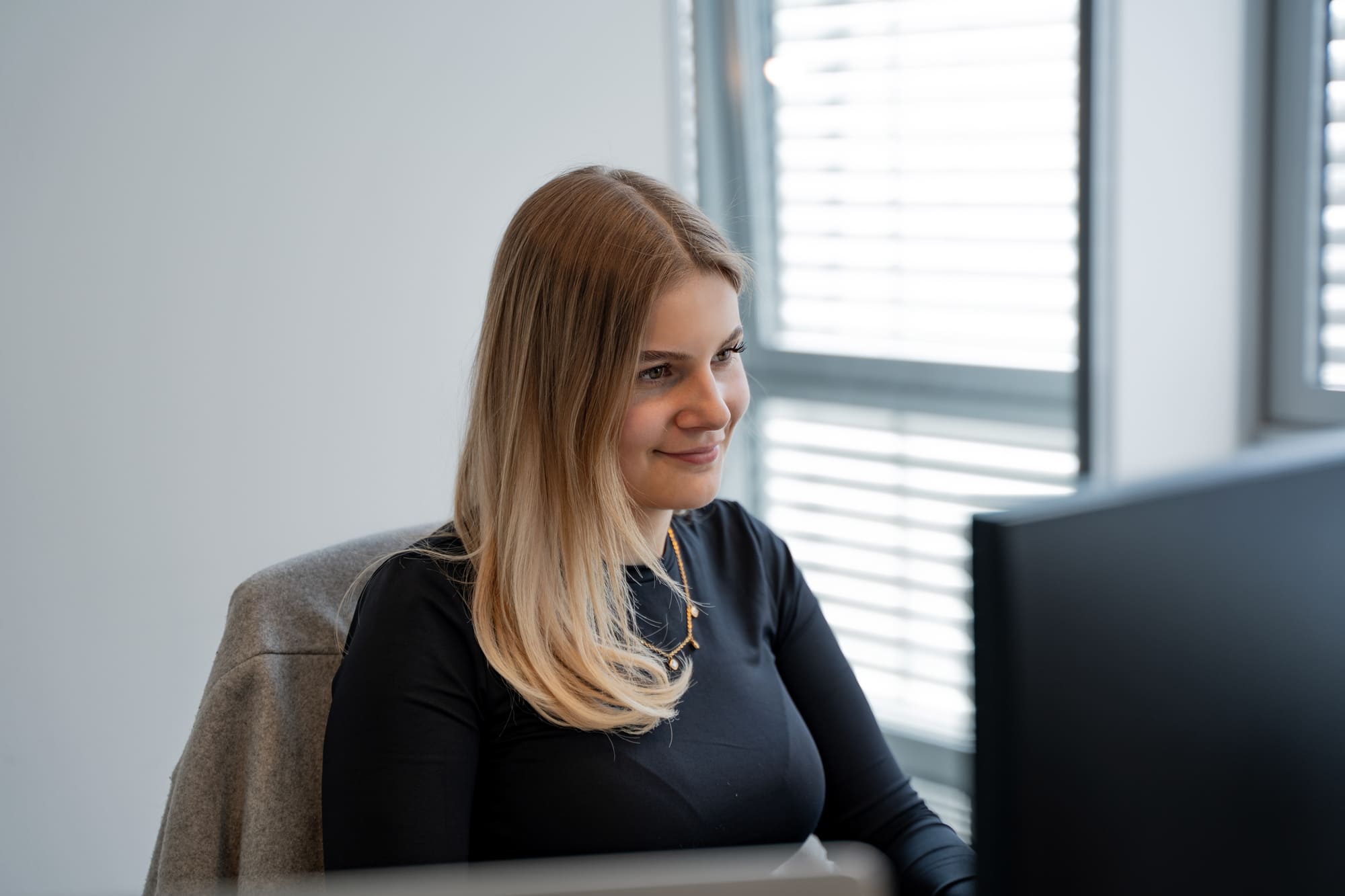 Leonie aus dem Team von digitalbynature am Arbeitsplatz am Fenster